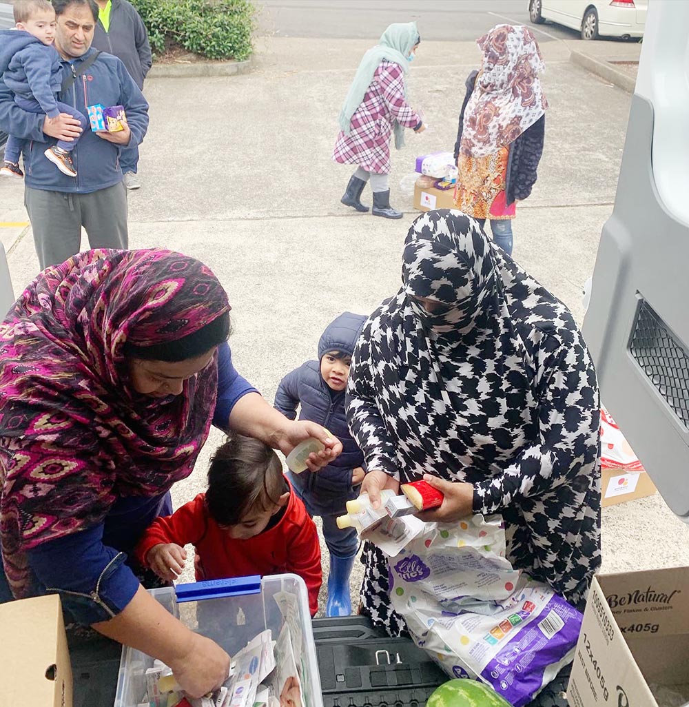 Women wearing headscarves taking food out of boxes