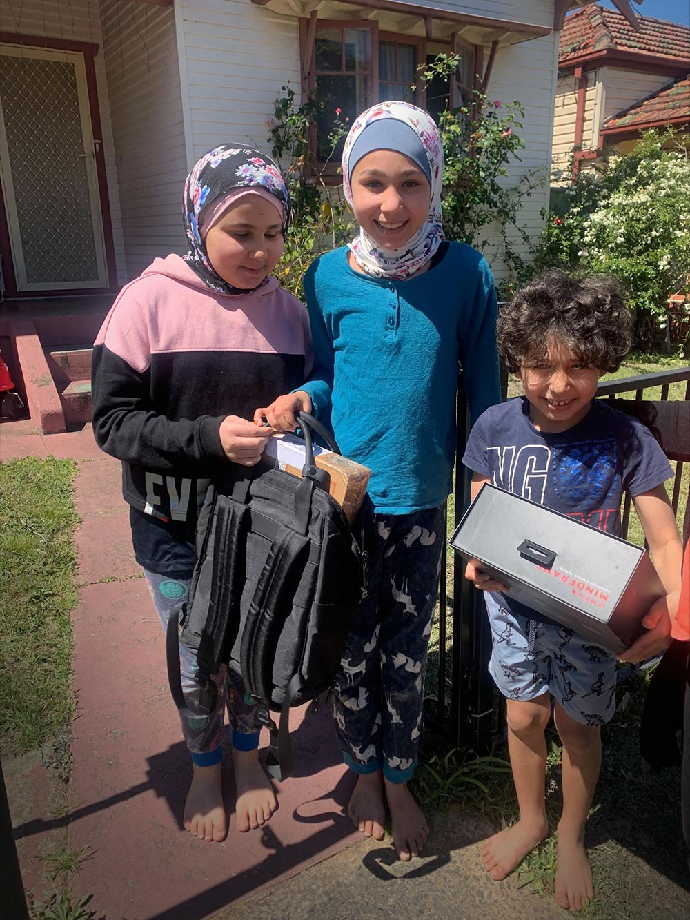 Three children holding laptops boxes