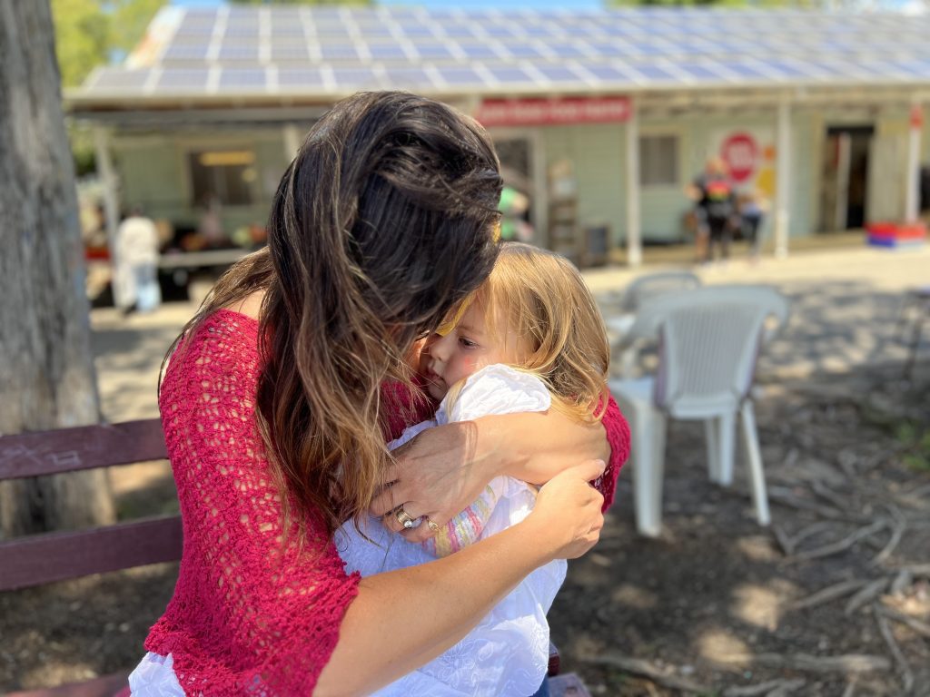Kim gives her daughter a hug outside Addi Road Food Pantry Marrickville. Photo Mark Mordue.